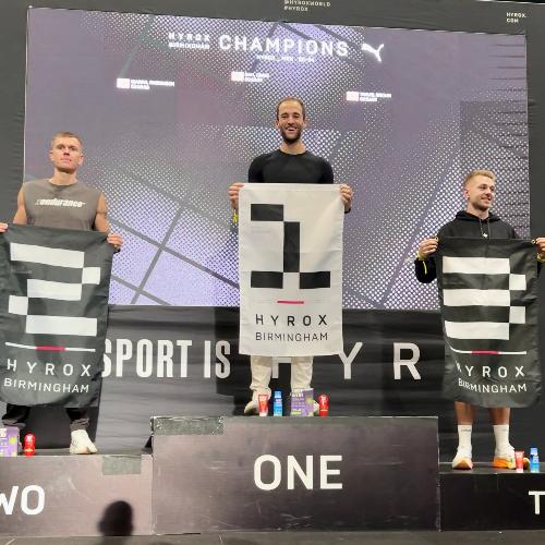 Sam Craig celebrating his HYROX win on the podium at Birmingham NEC