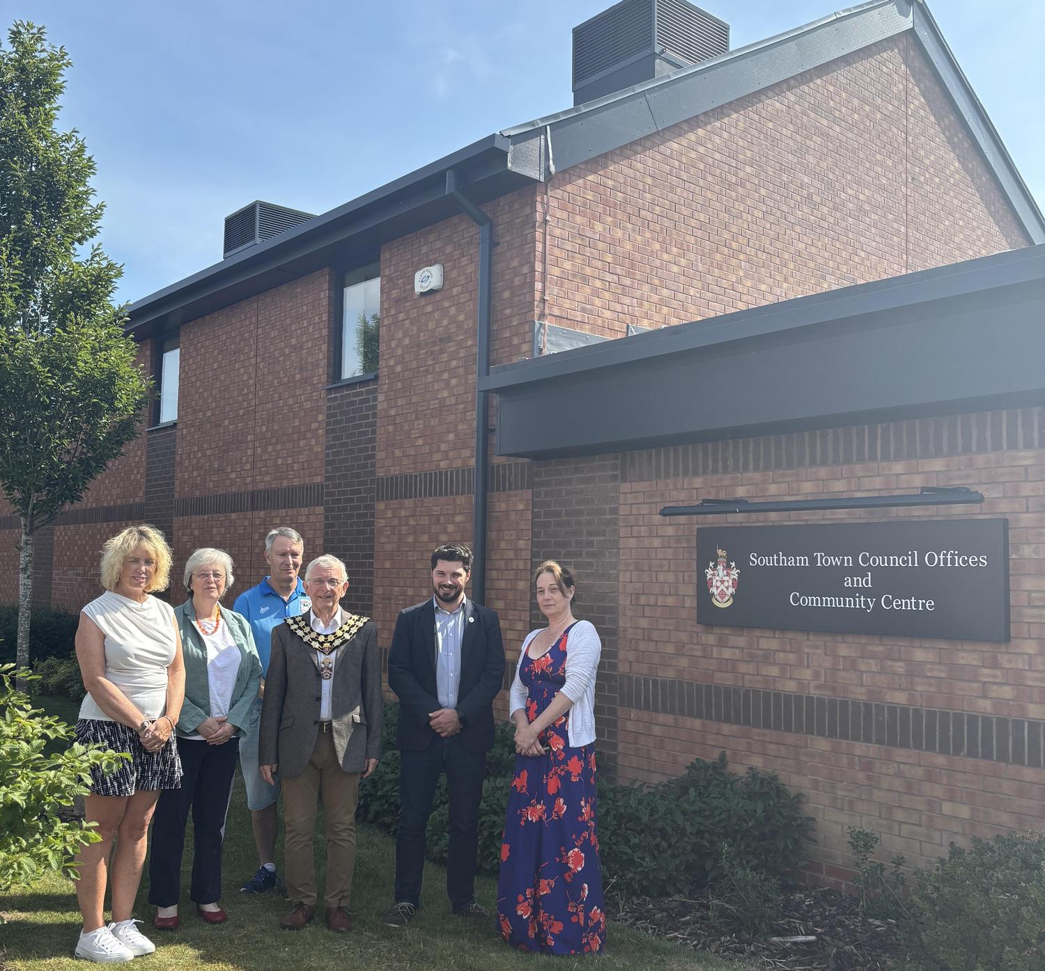 Group photo outside Southam Town Council Offices and Community Centre beside the building sign.